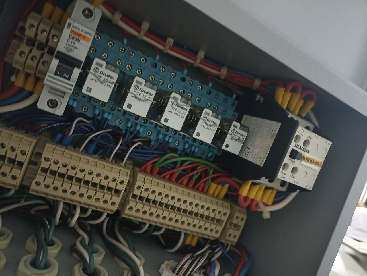 Interior de tablero eléctrico industrial con interruptor termomagnético, relés y contactor